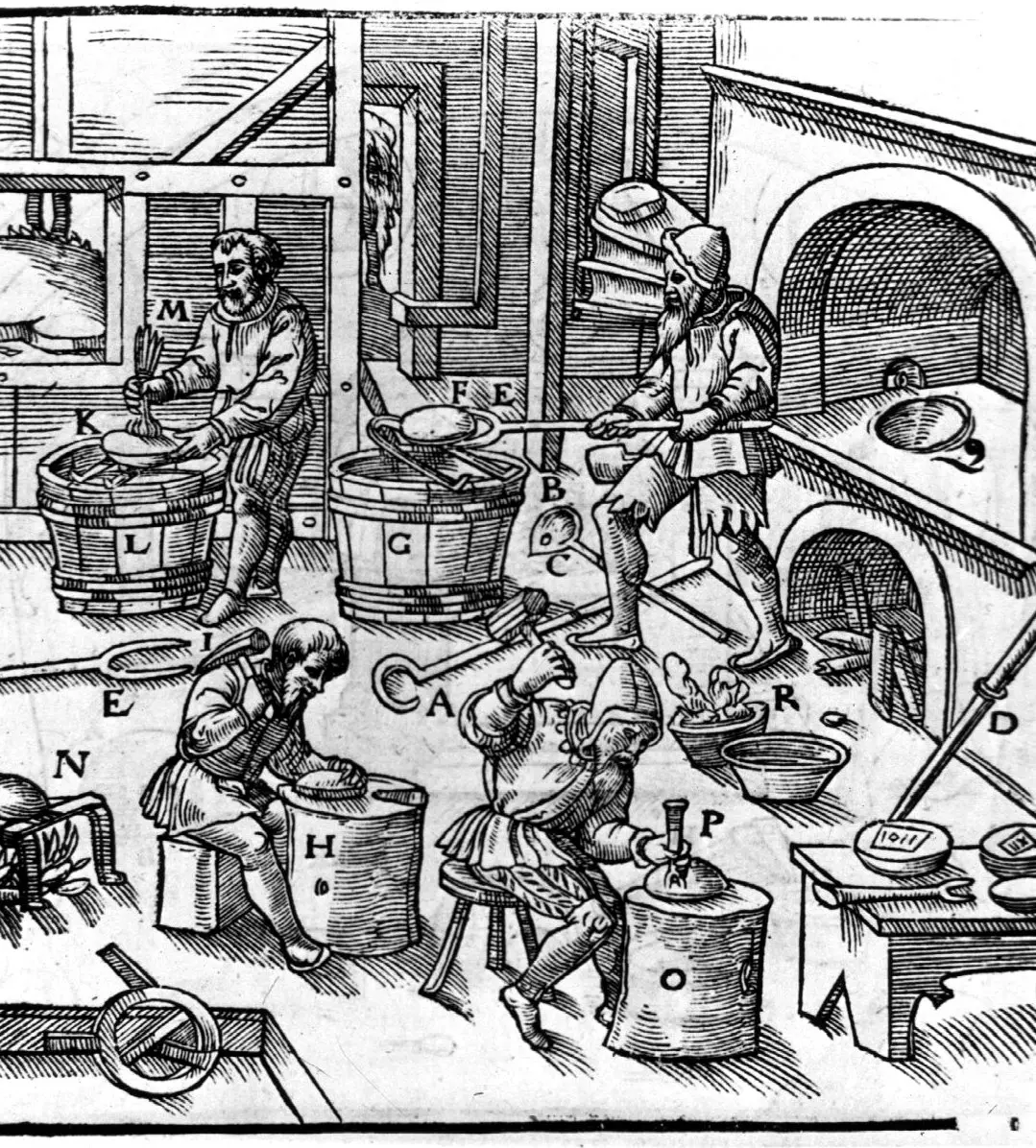 A woodcut of a workshop where four men work at four stages of one metallurgical process.